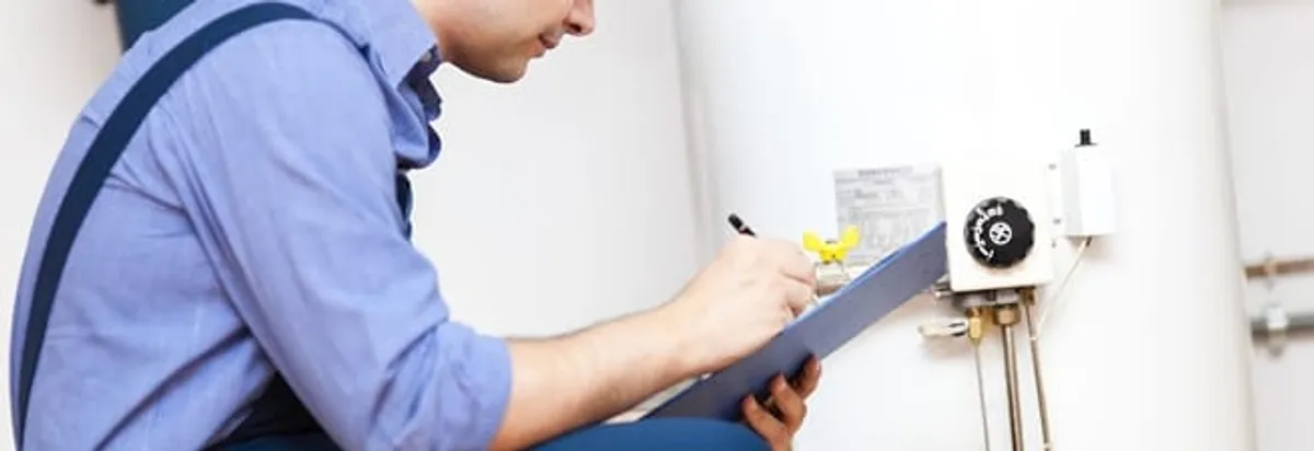 Water heater repair technician inspecting the unit and recording service notes in Saint Louis, MO